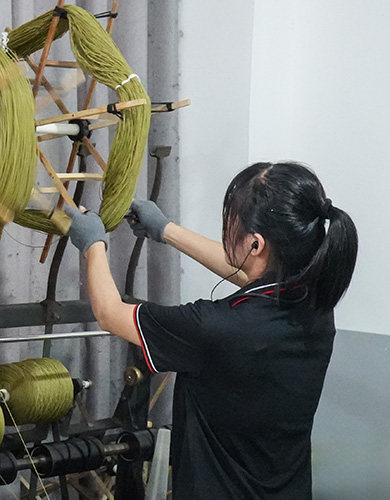 Artisan préparant des écheveaux de laine verte pour tapis touffeté sur mesure